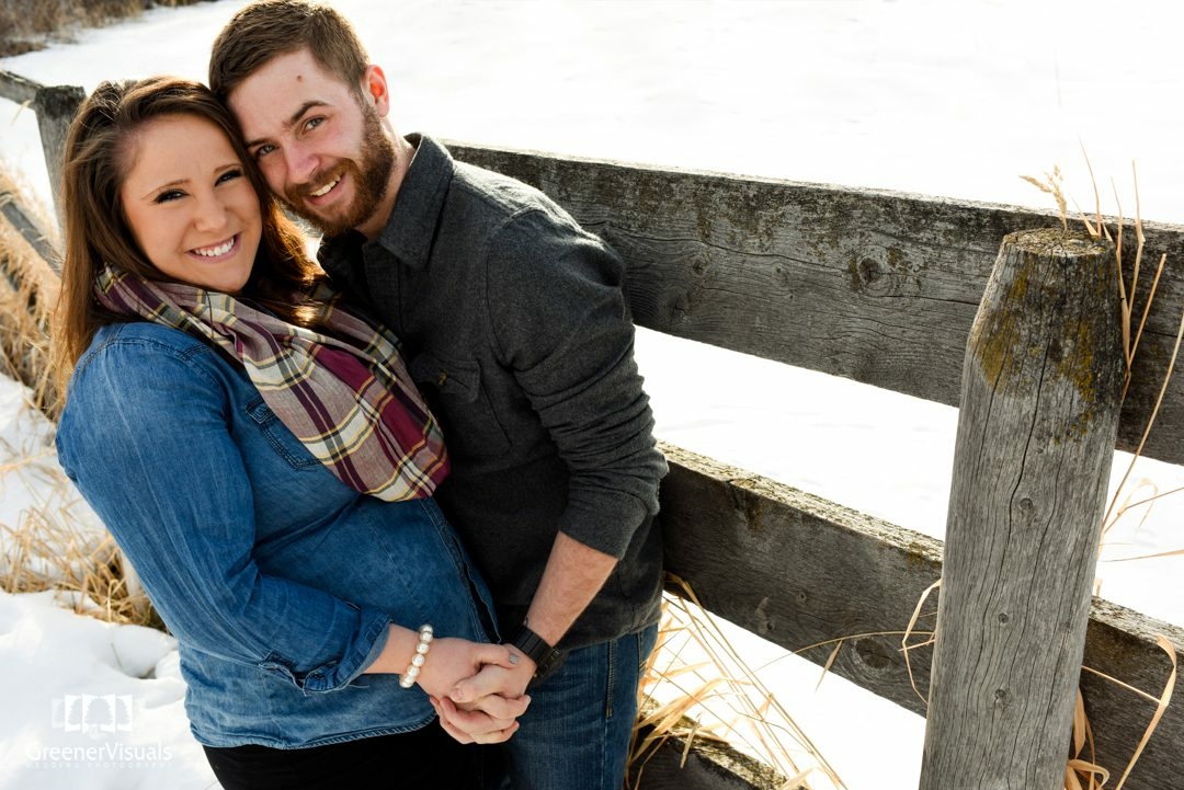 engaged-couple-by-old-fence-at-Story-Mill-Park-Winter-Engagement-Portrait