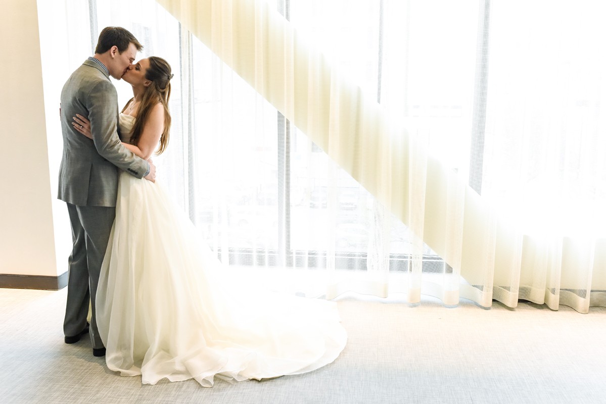 wedding-couple-first-look-kiss-at-The-Godfrey-Hotel