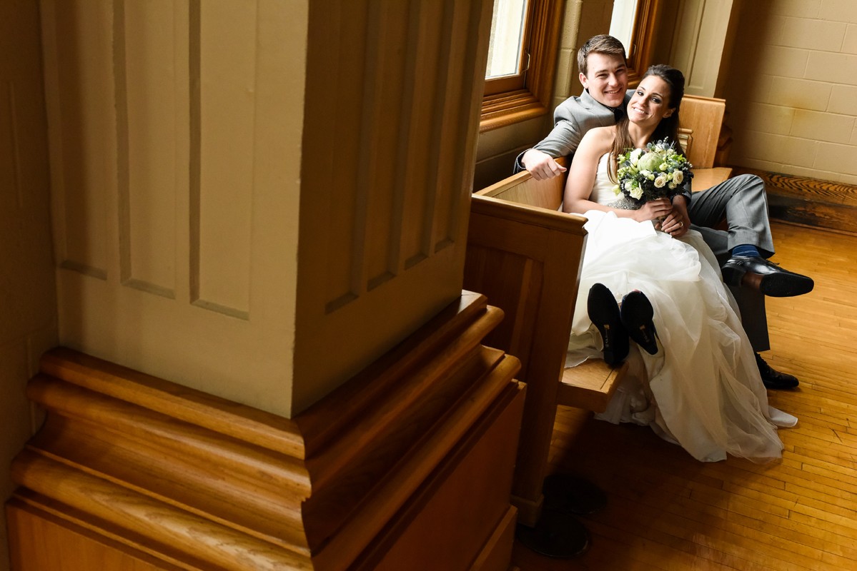 wedding-couple-relax-on-bench-of-church-of-the-holy-family