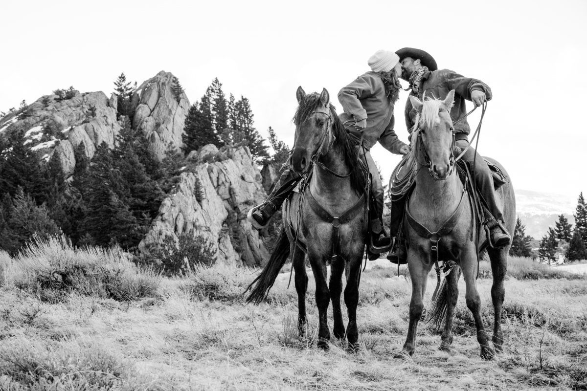 cowboy-couple-kiss-on-Horseback-during-Engagement-Portraits