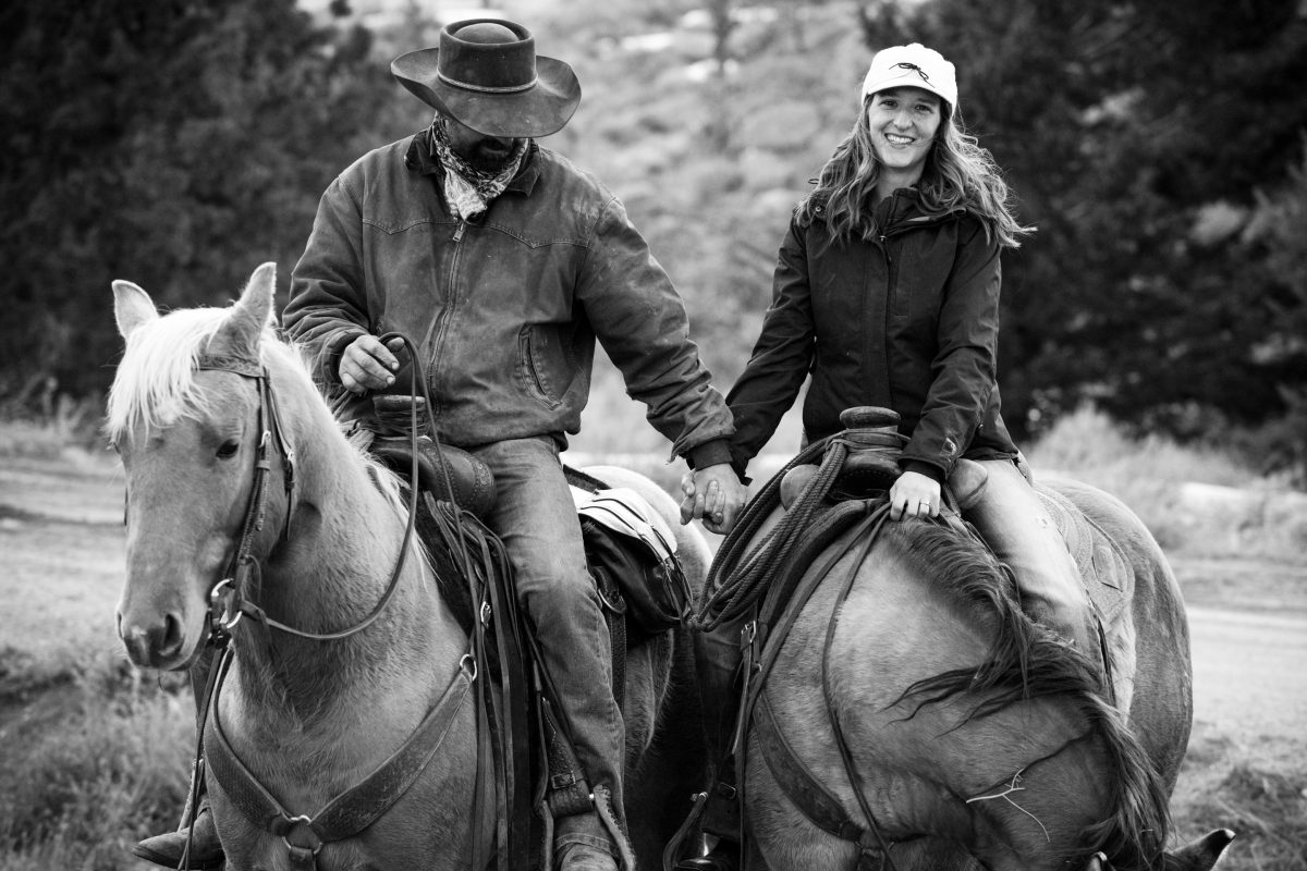 cowboy-couple-ride-holding-hands-during-Horseback-Riding-Engagement-Portraits