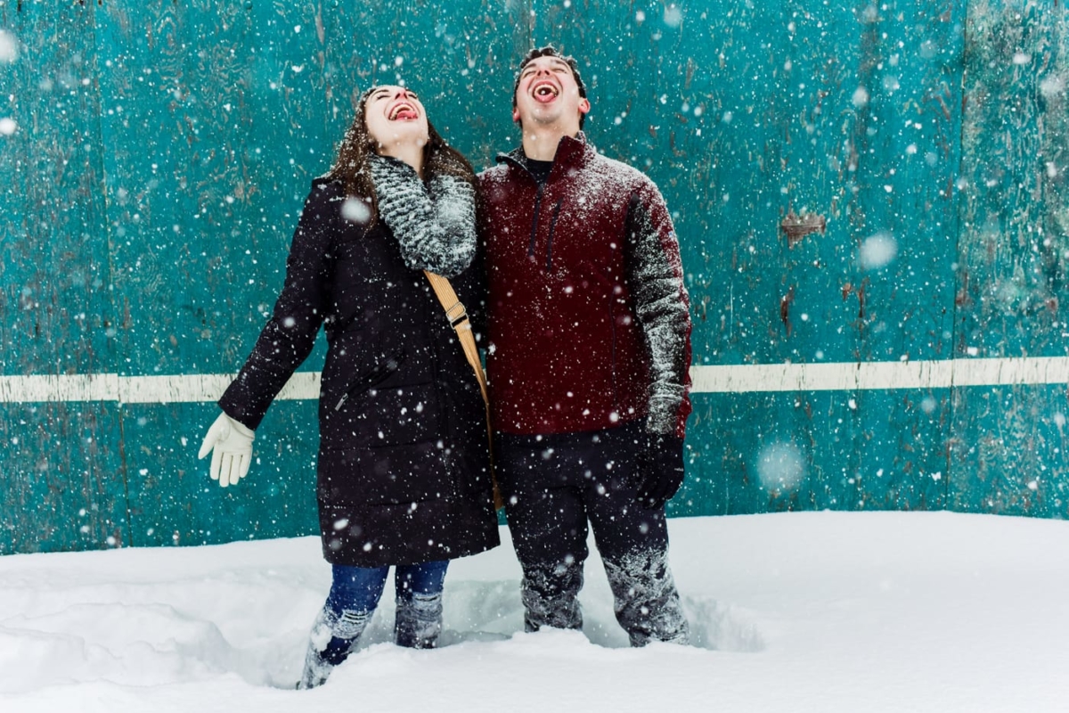 engaged-couple-catch-snowflakes-on-tongues-Bogert-Park-Snowstorm-Portraits