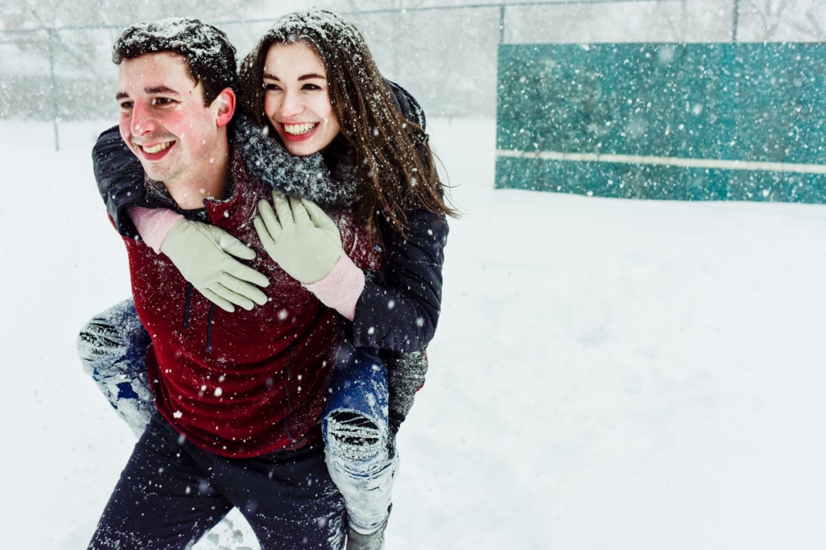 woman-rides-on-back-of-man-during-Bogert-Park-Snowstorm-Portraits
