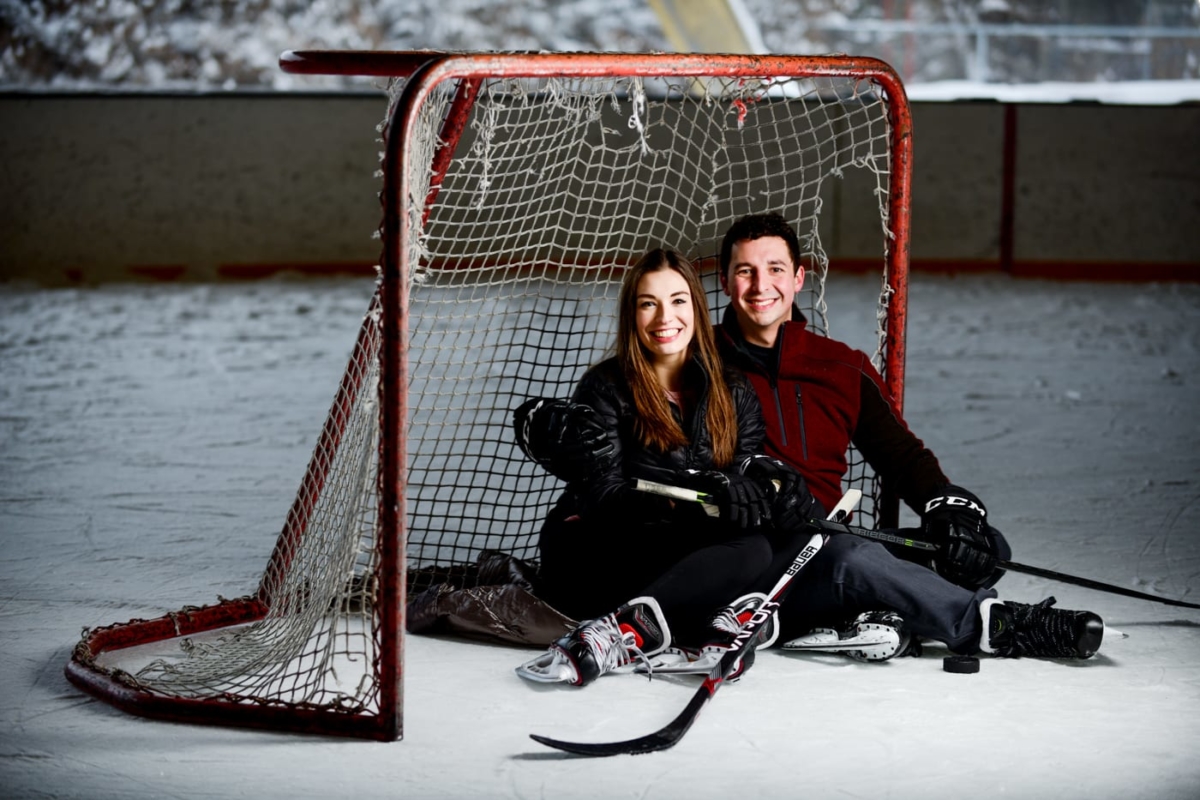 engaged-couple-sit-under-hockey-net-during-Bogert-Park-Snowstorm-Portraits