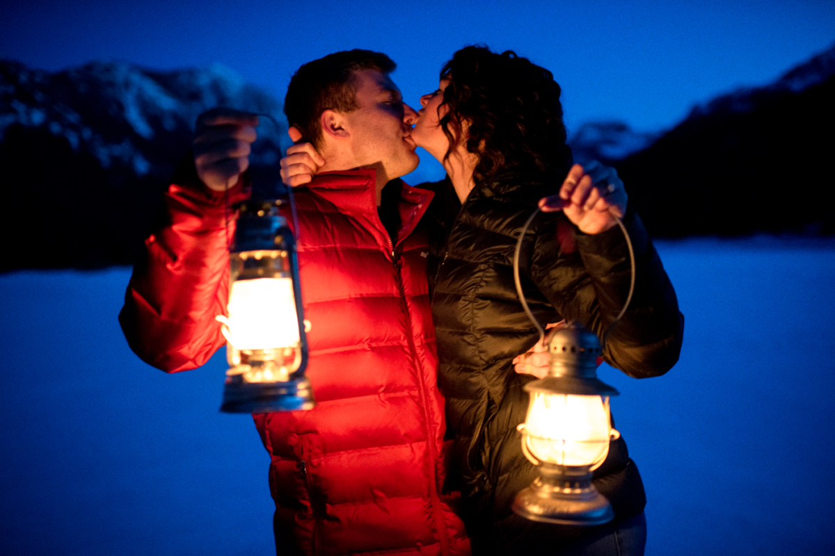 engaged-couple-kiss-with-oil-lanterns-during-Hyalite-stargazing-engagement-portraits