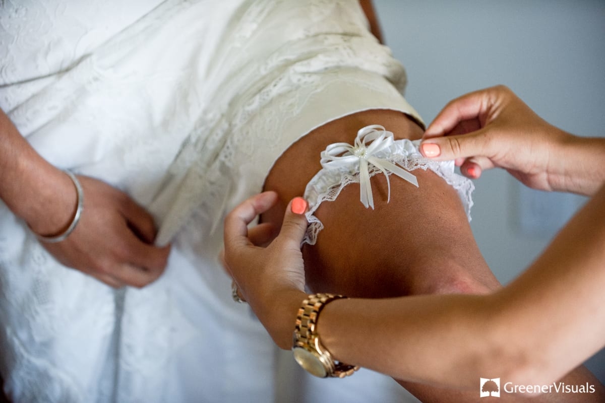 bride-gets-help-putting-on-wedding-garter