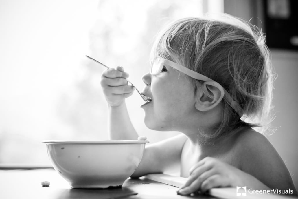young-girl-in-glasses-eating-cheerios-Anchorage-Alaska-Destination-Family-Portrait-Photographer