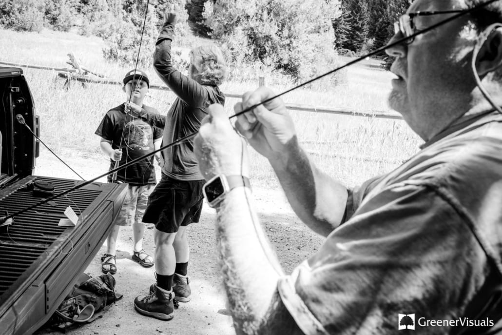 grandma-helping-grandson-rig-up-flyrod-during-their-Flyfishing-Family-portrait-session-on-the-Gallatin River
