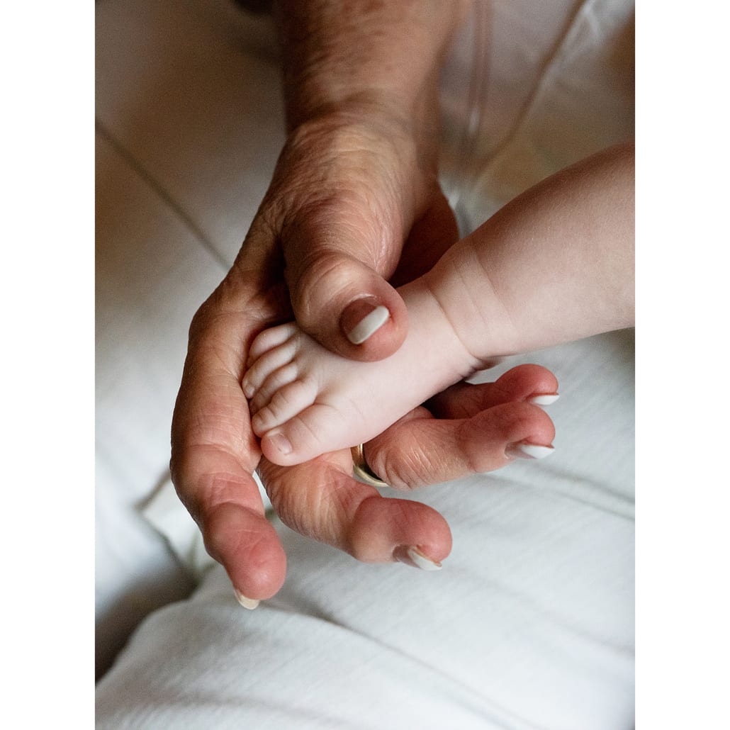 grandmas-hands-holds-newborn-foot
