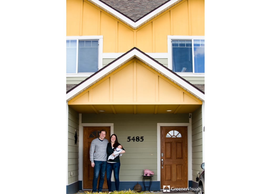 couple-with-newborn-and-yellow-house