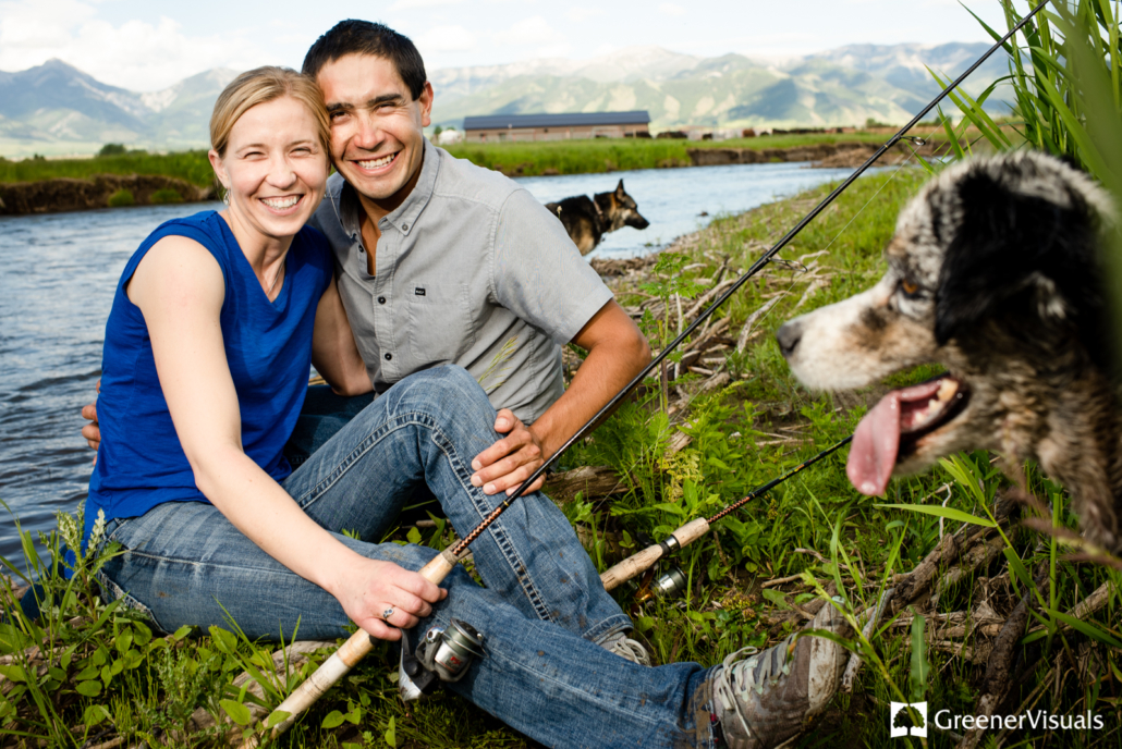 engaged-couple-with-fishing-poles-sit-on-riverbank-as-dogs-look-on-East-Gallatin-River
