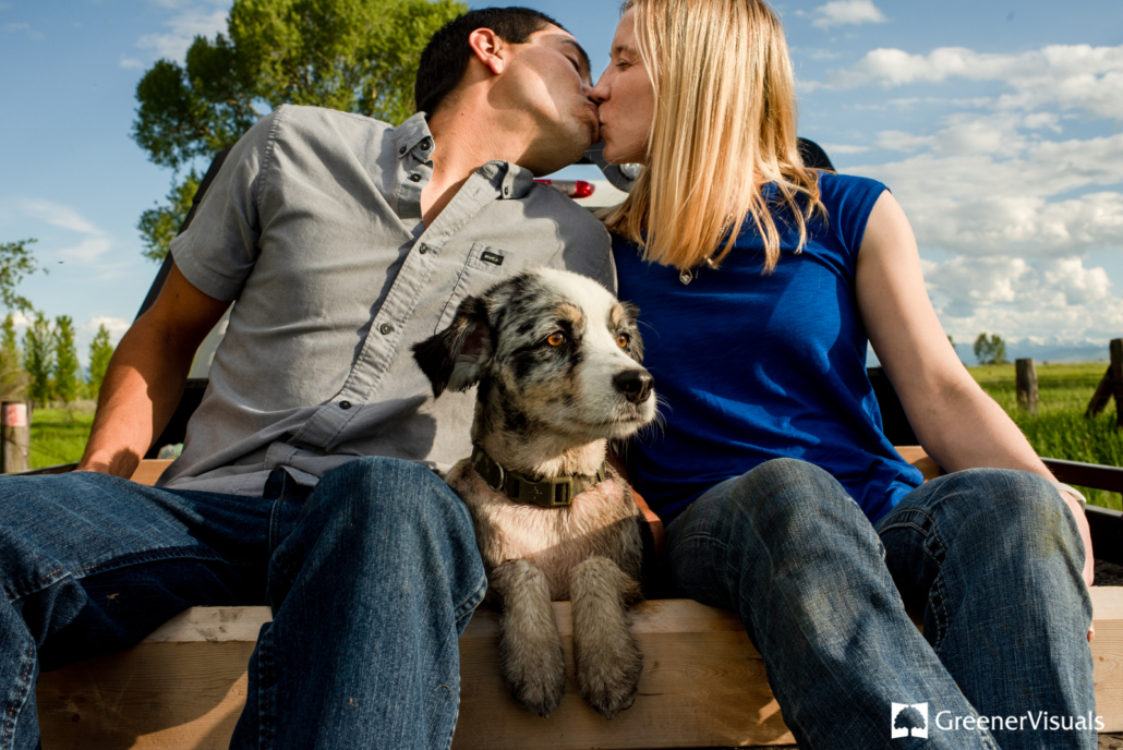 engaged-couple-kissing-as-dog-looks-onto-East-Gallatin-River
