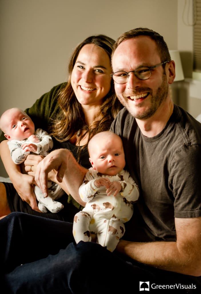 Family-portrait-of-parents-holding-newborn-twin-boys