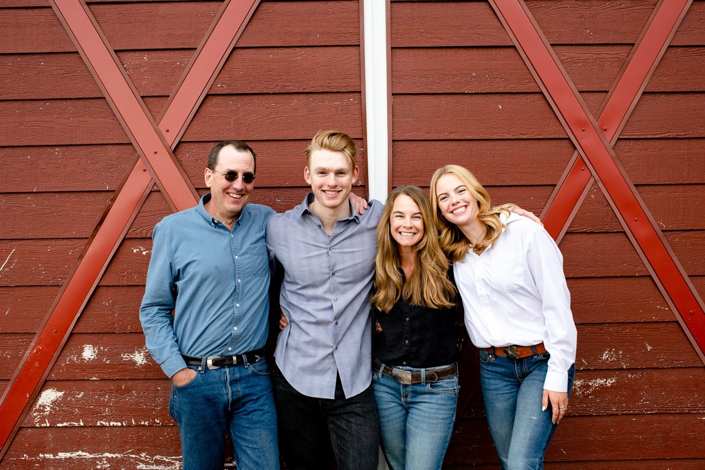 Family-group-hug-in-front-of-Red-Barn