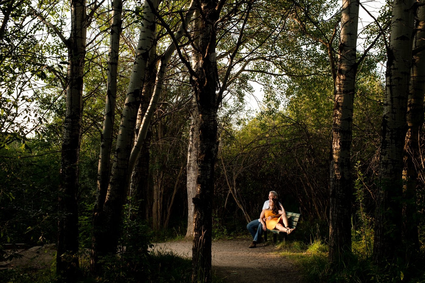 Couple-embracing-on-forest-park-bench-Bozeman