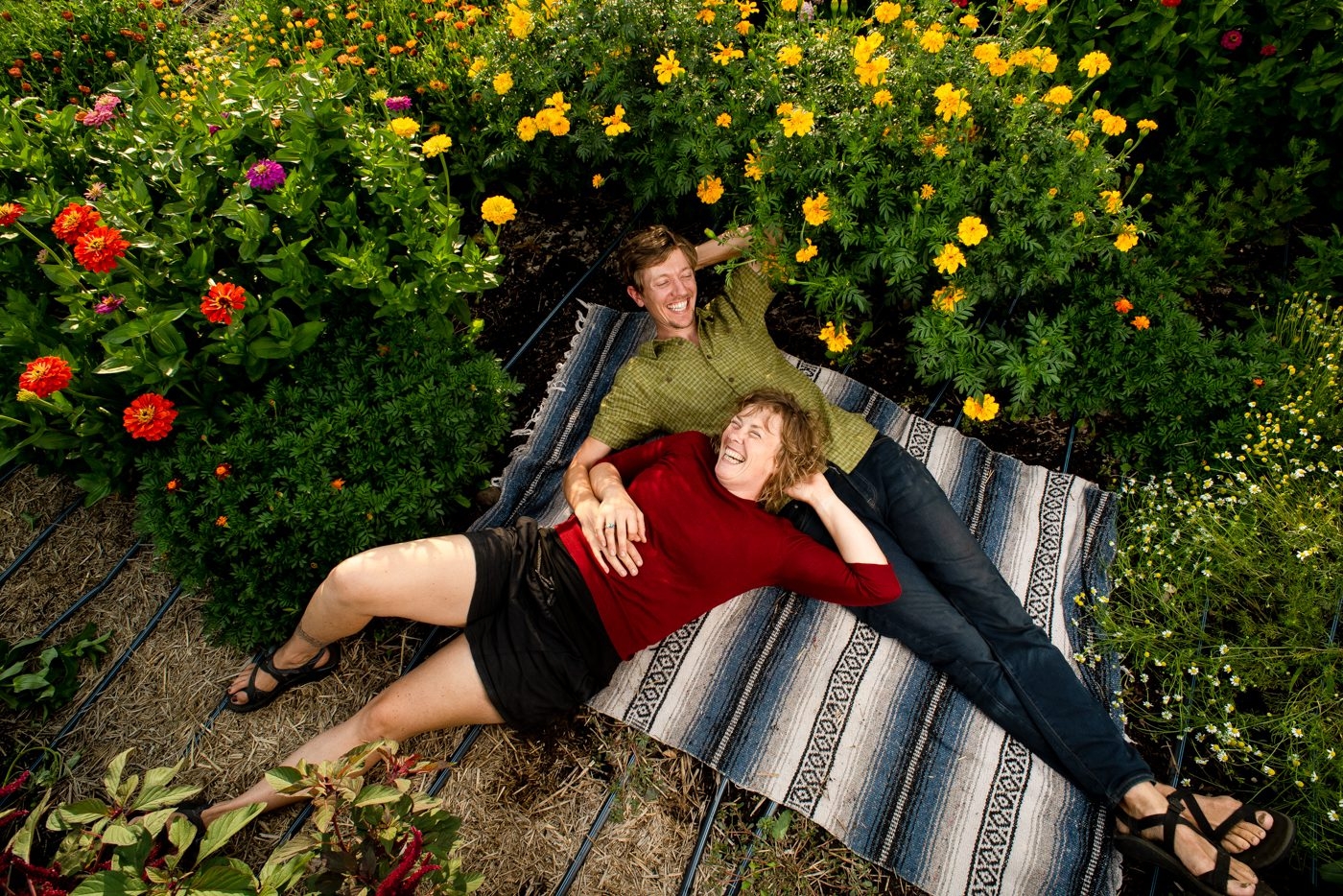 Farming-Couple-laughing-laying-in-flower-garden
