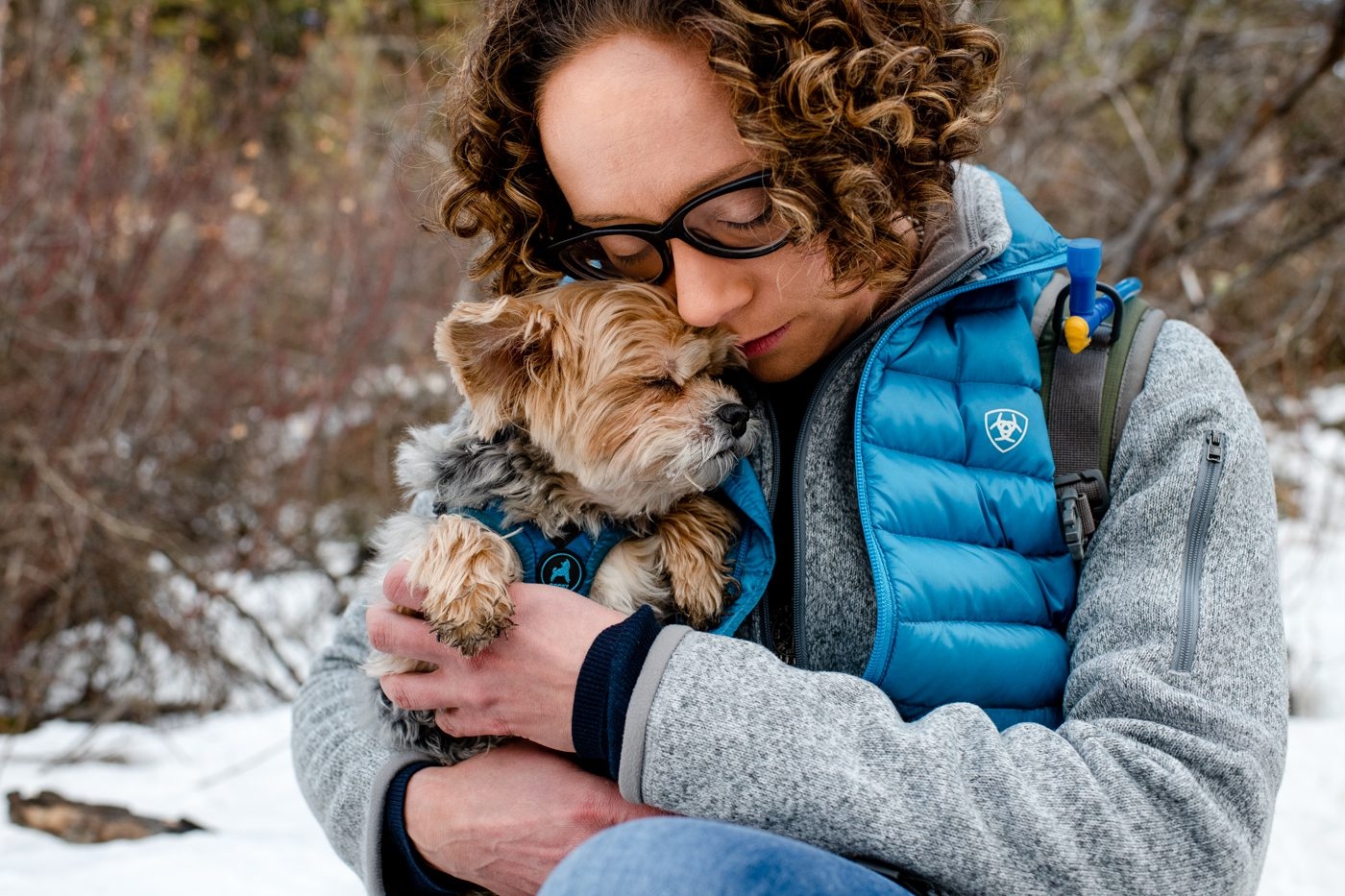 woman-lovingly-hugs-her-small-dog-on-trail-Best-of-2021-Portraits