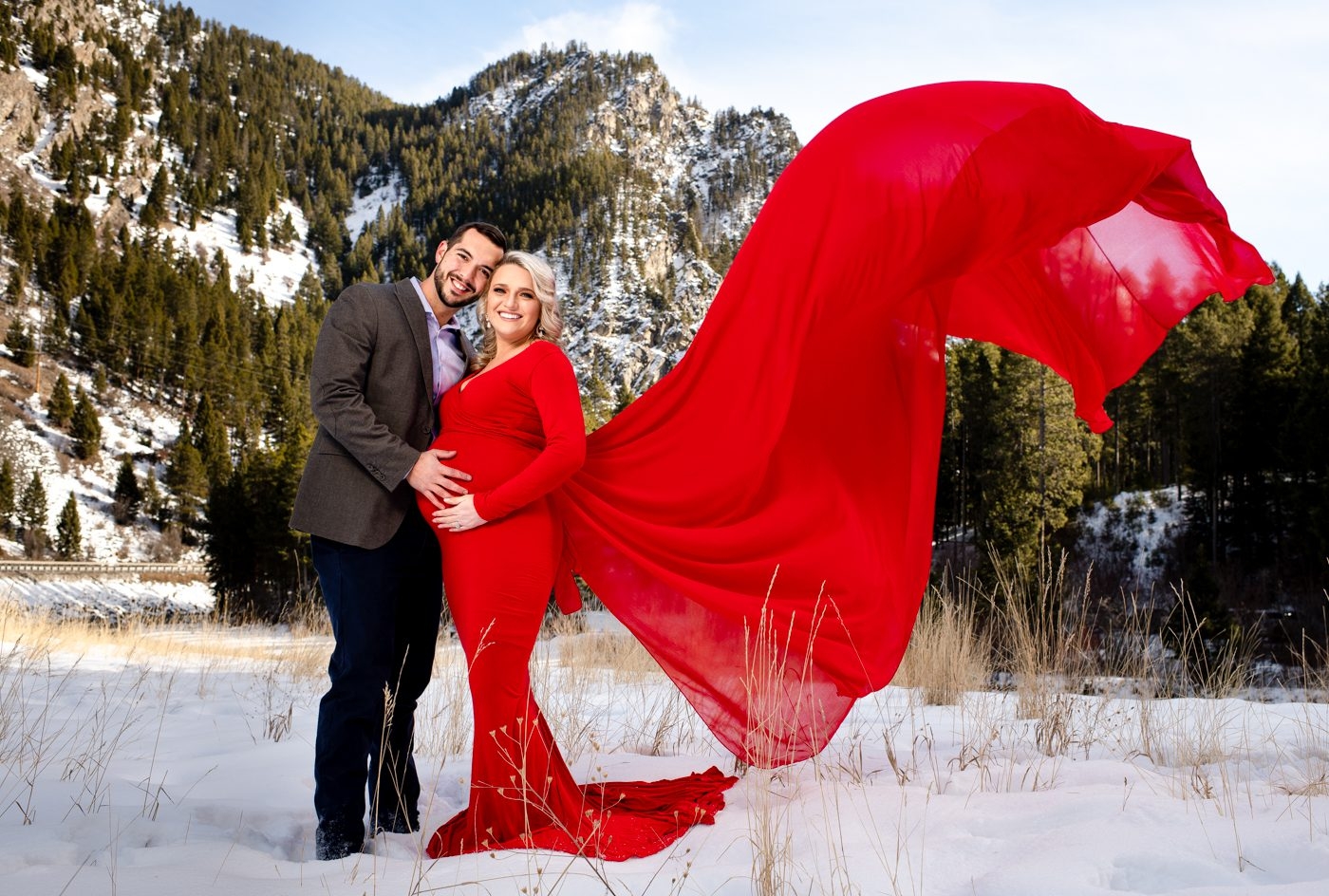 Maternity-couple-with-flowing-red-dress-in-big-sky-montana