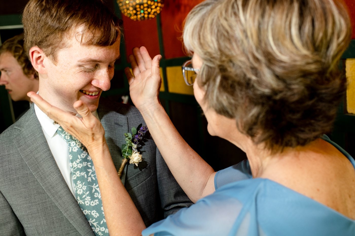 Mother-of-bride-finishes-boutonniere-placement