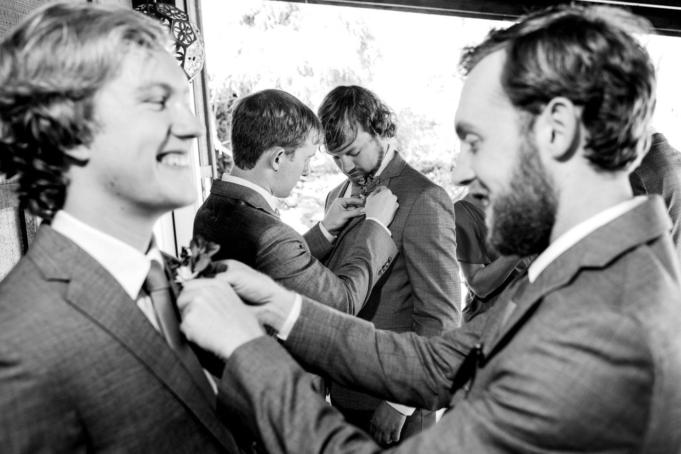 laughing-groomsmen-tying-neckties-together