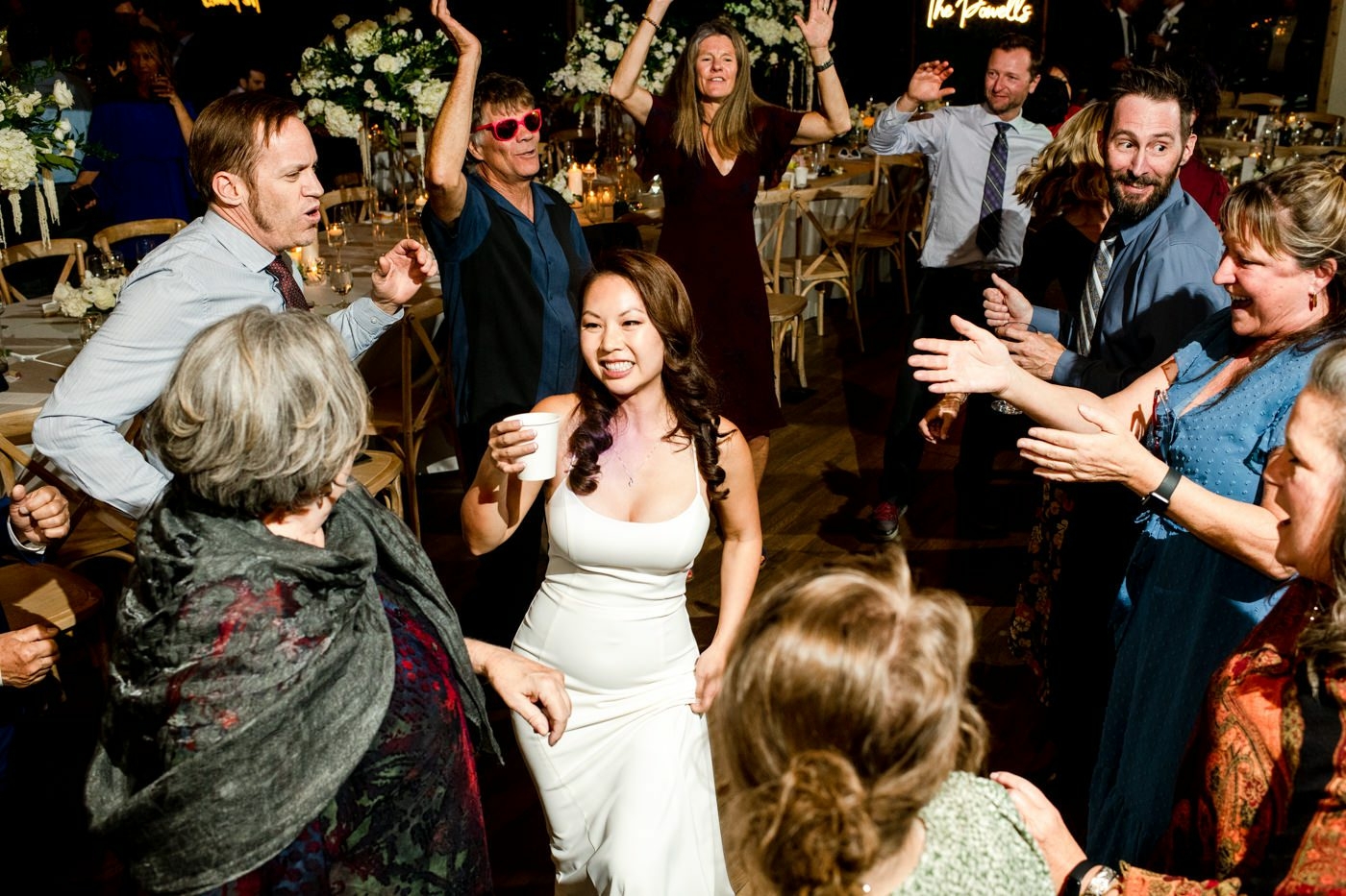 bride-dances-with-guests-at-Fall-River-Village-Sky-View-Lodge-Estes-Park-Colorado-wedding