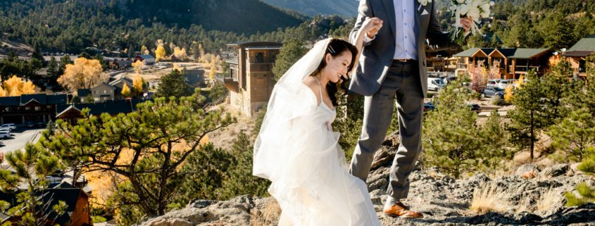 wedding-couple-climb-for-mountain-view-at-Skyview-at-Fall-River-Village-Resort-Estes-Park-Colorado