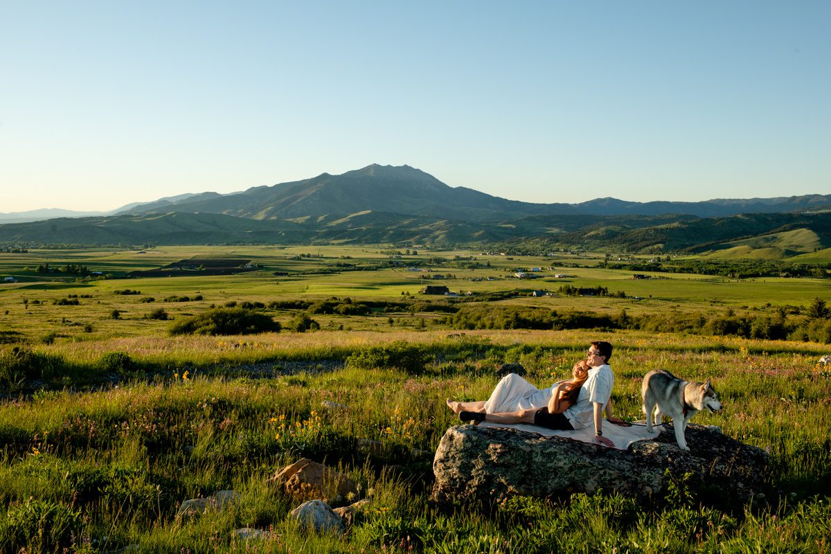 couple-sit-on-boulder-watching-sunset-at-Mount-Ellis-Trailhead