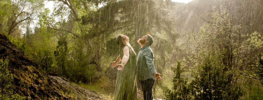 engaged-couple-smile-at-rain-during-Montana-Ruby-Valley-Rainstorm-Engagement-session