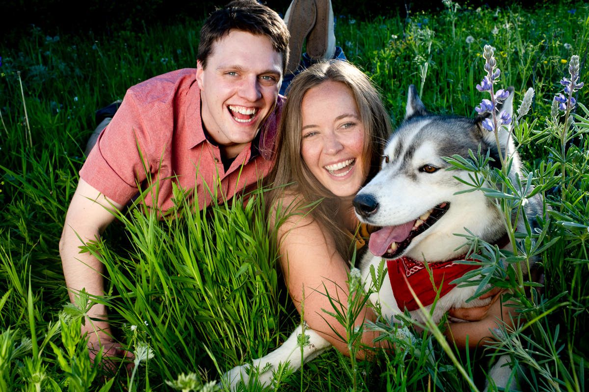 laughing-couple-with-dog-at-Mount-Ellis-Trailhead-engagement-portraits