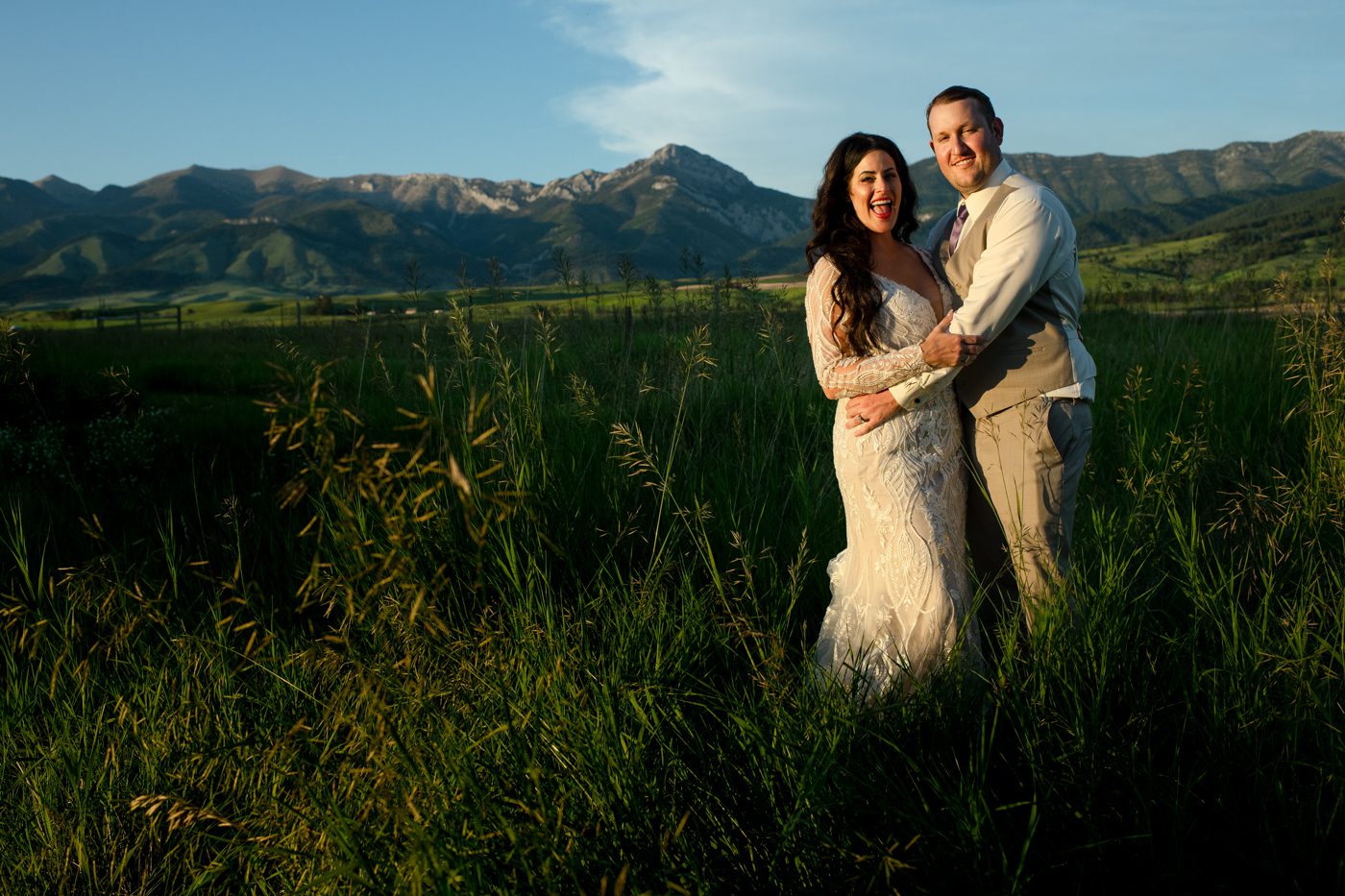Bride-and-groom-embrace-in-sunlight-near-bridger-mountains