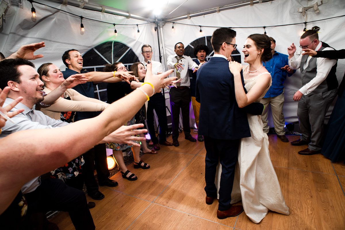 wedding-couple-dance-with-friends-surrounding-them-on-wedding-reception