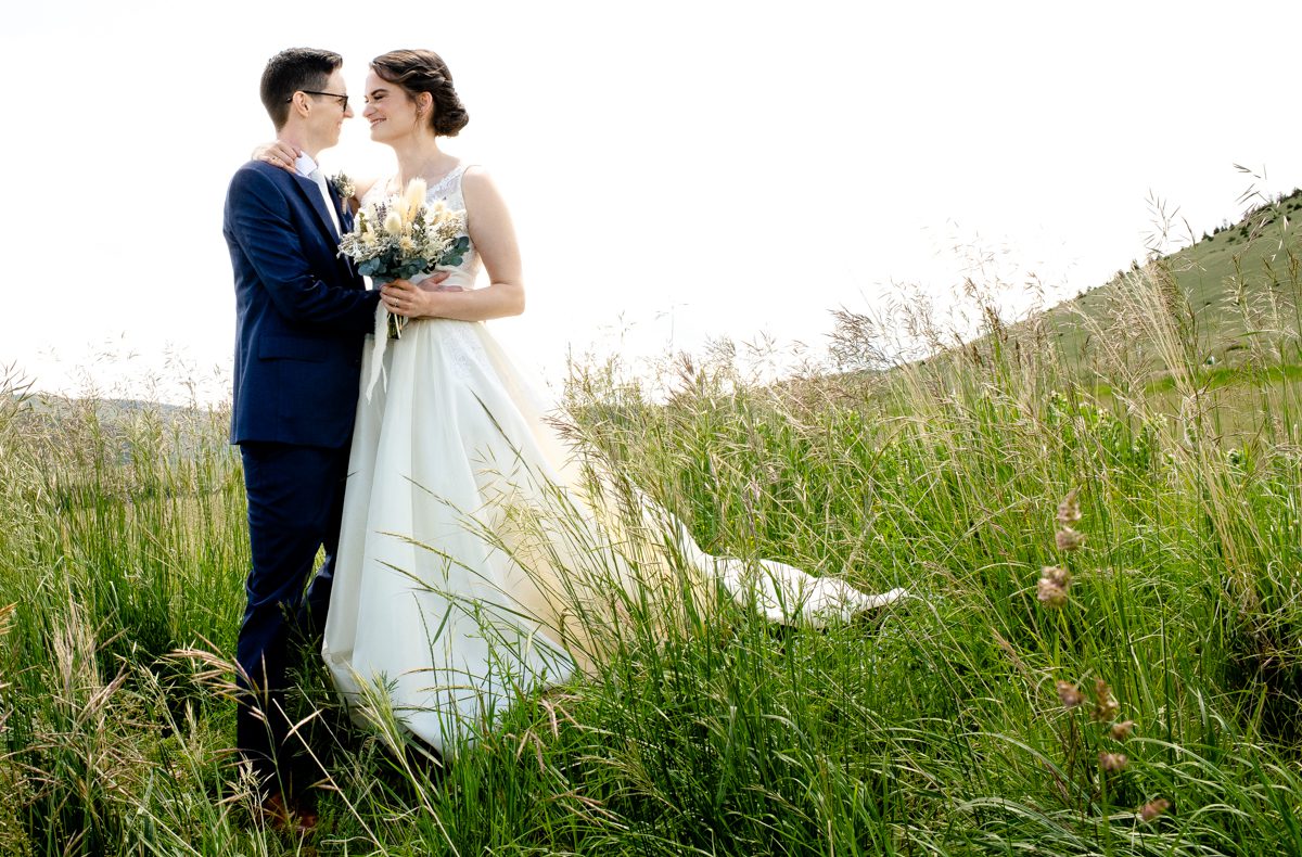 LGBTQ-wedding-couple-stand-in-tall-grass-Madison-Valley-Montana