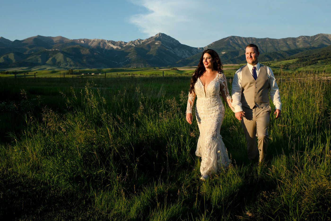 Newlyweds-walk-in-front-of-bridge-mountains-Roys-Barn-Montana