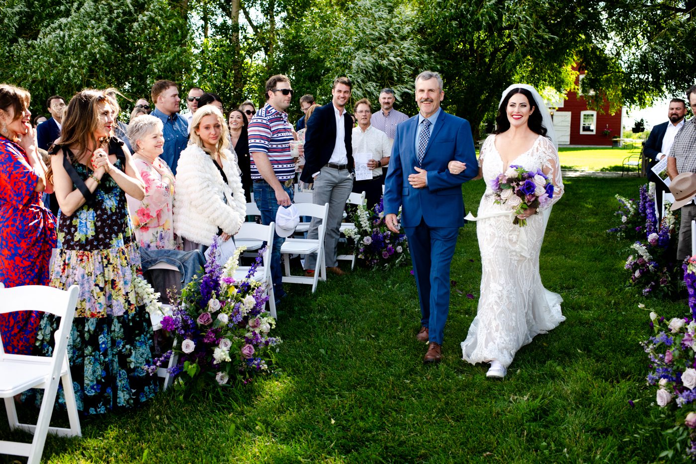 guests-watch-bride-walk-down-aisle-with-dad-at-roys-barn