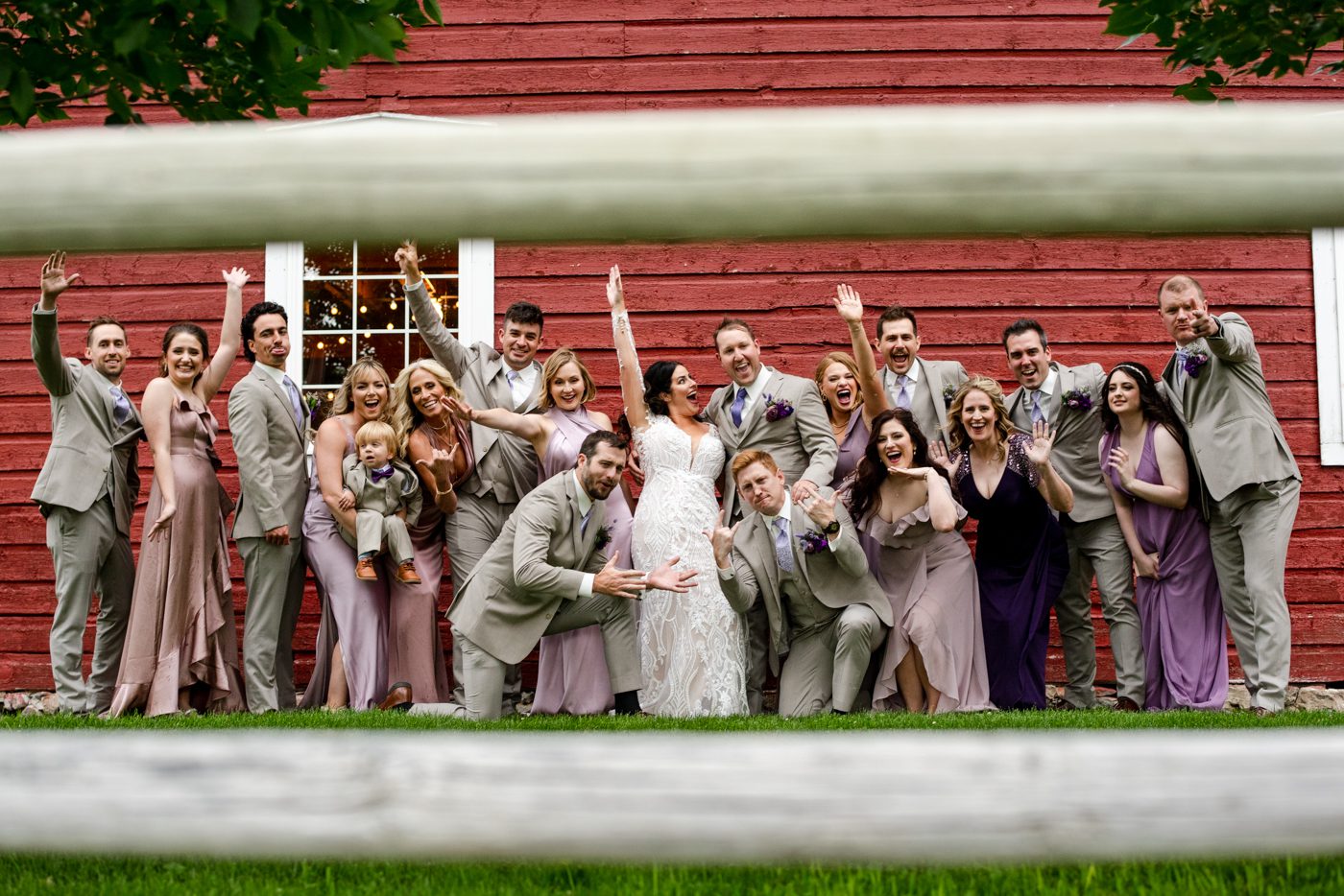 wedding-party-cheer-for-bride-and-groom-against-red-barn